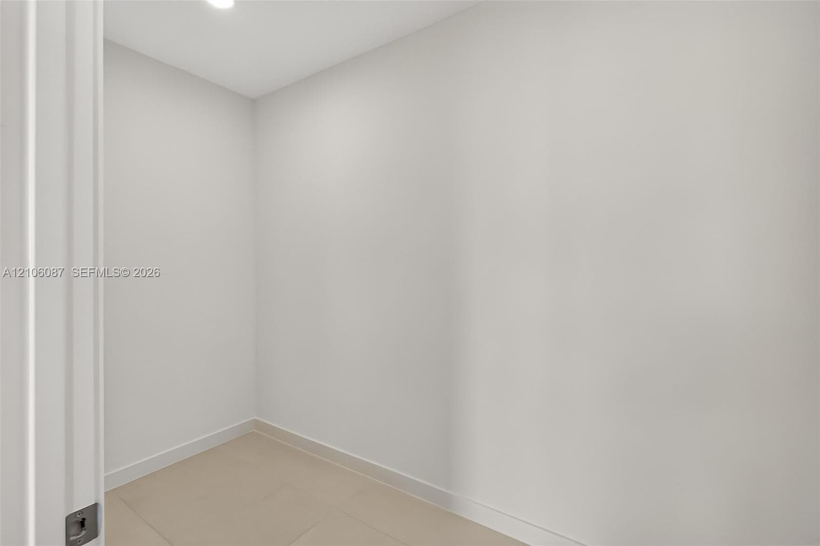 Neutral-toned interior space featuring smooth wall surfaces and large-format tile flooring