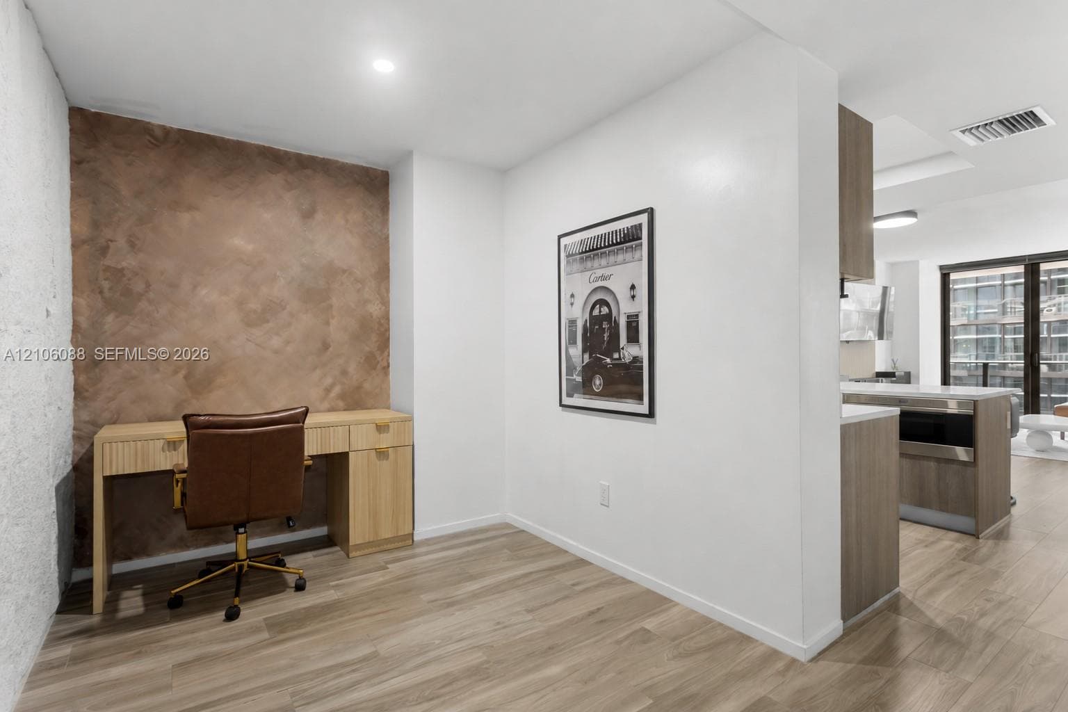Textured accent wall featuring a troweled finish, wood-finish flooring, and recessed ceiling lighting