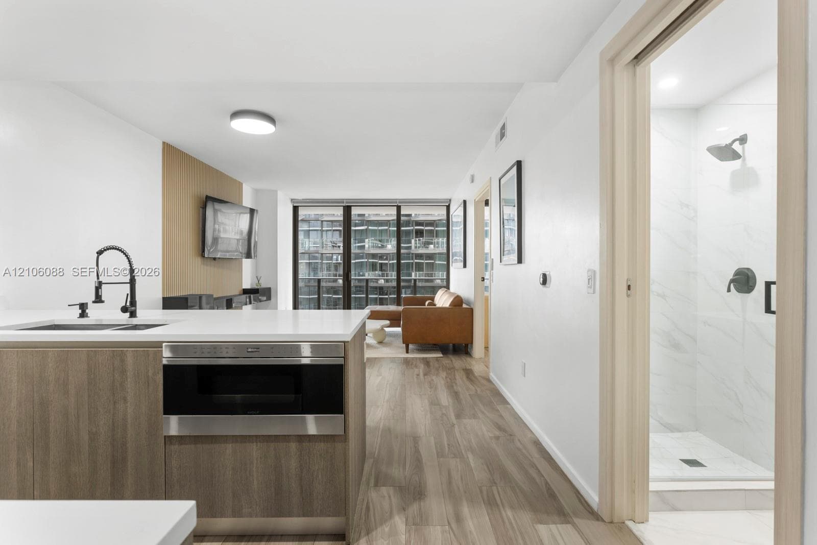 Kitchen featuring a white countertop, wood-finish cabinetry, and a dark-finish gooseneck faucet