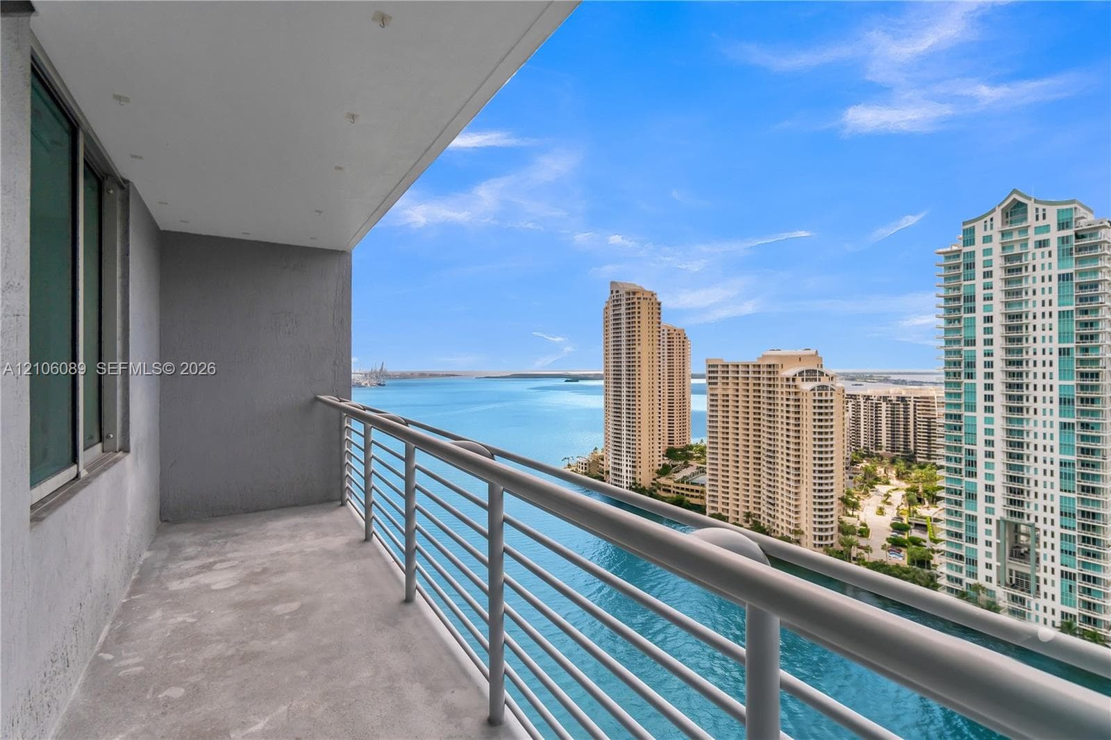 Covered balcony featuring concrete flooring, recessed ceiling lighting, and a metal railing