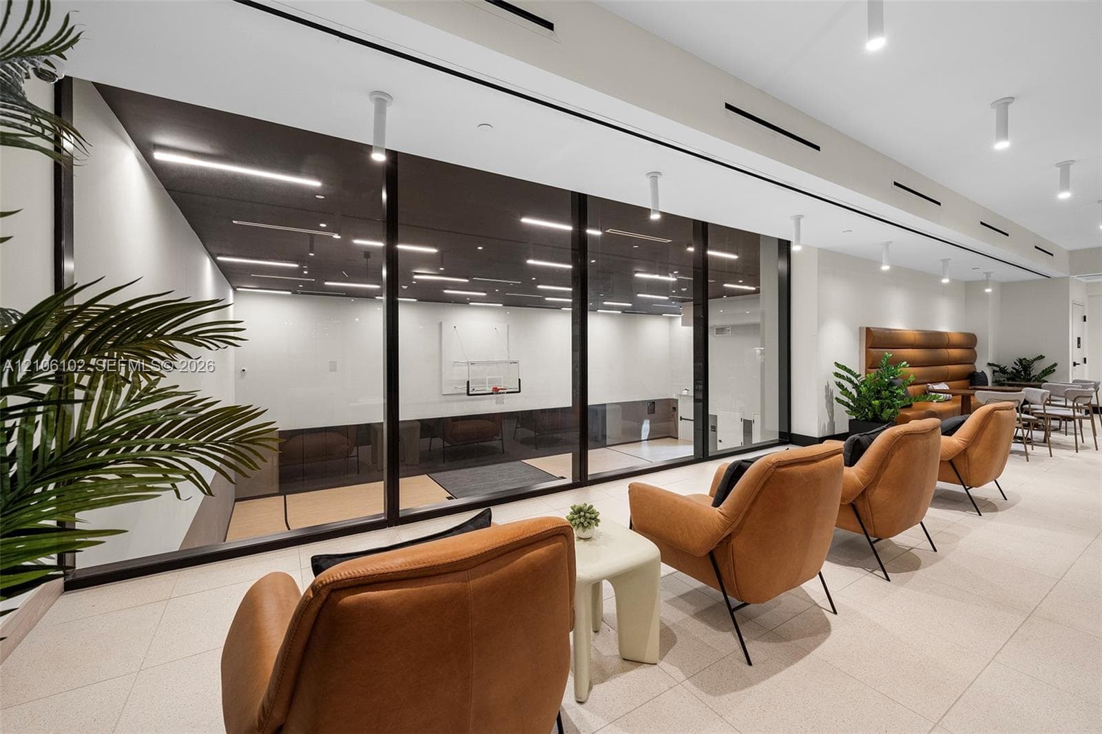 Expansive interior featuring large-format tile flooring, recessed linear lighting, and an extensive floor-to-ceiling glass wall enclosure