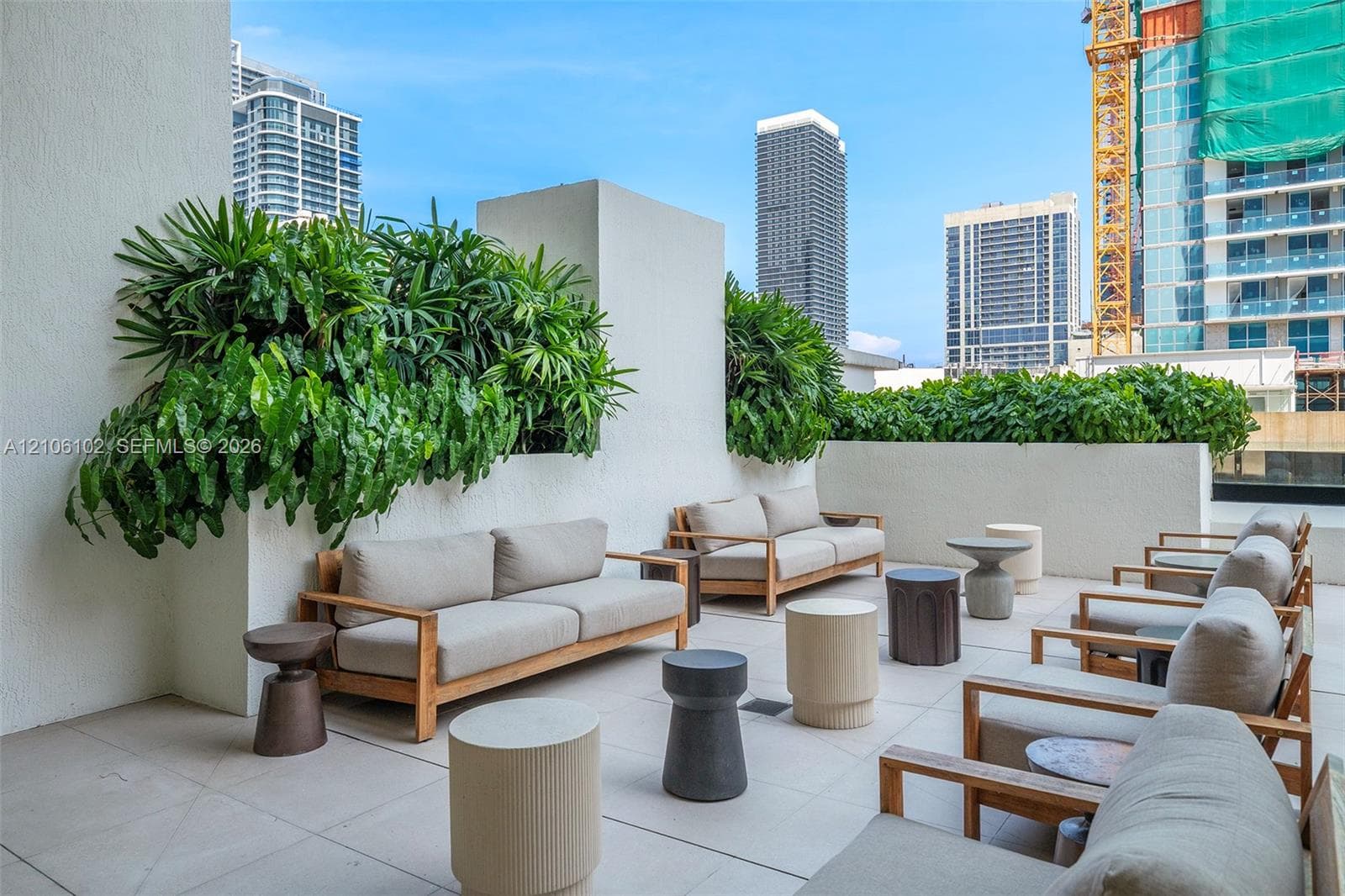 Expansive outdoor terrace featuring light-toned paved flooring and built-in masonry planters with integrated greenery
