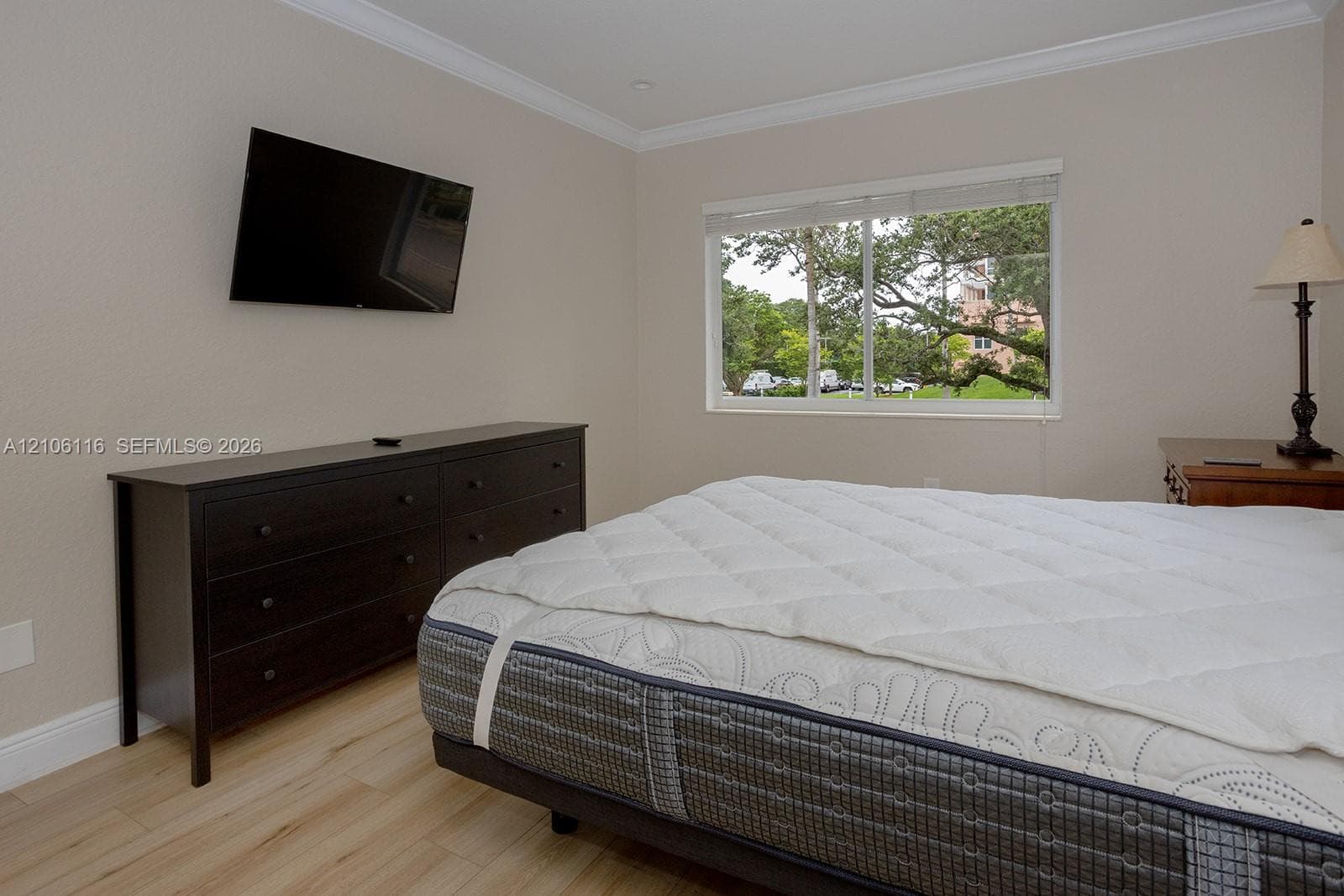 Neutral wall coloring, crown molding, wood-finish flooring, and horizontal sliding window