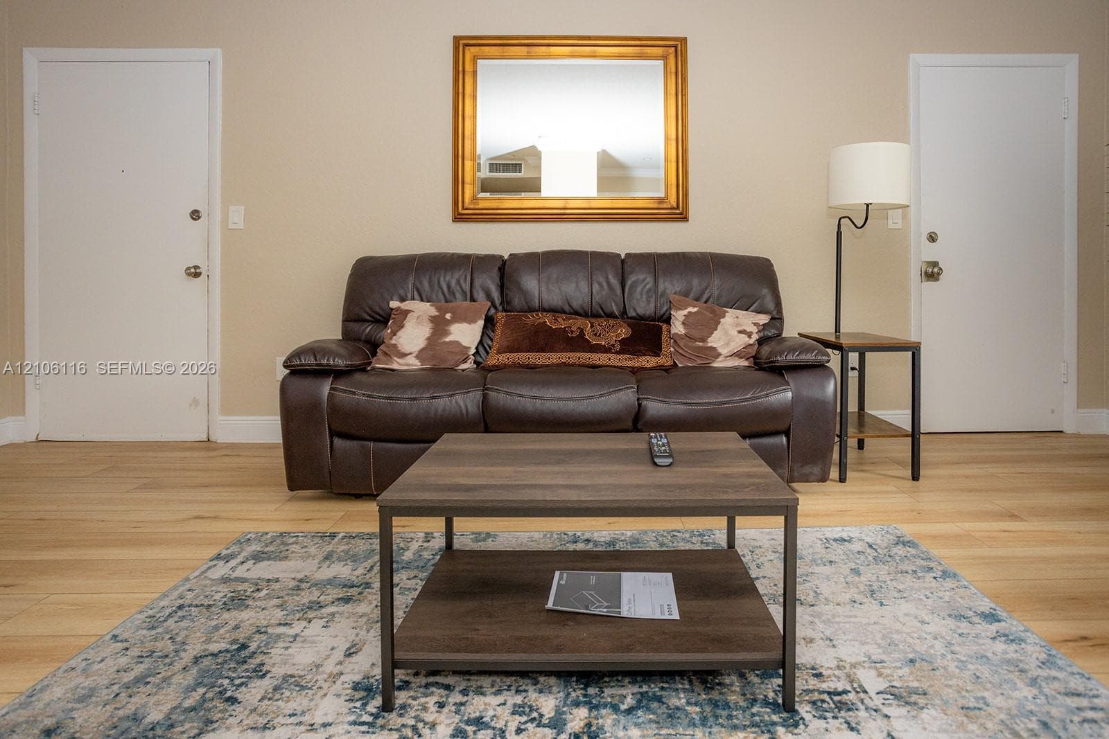 Neutral wall tones, wood-finish flooring, and two interior doors with brushed metal hardware