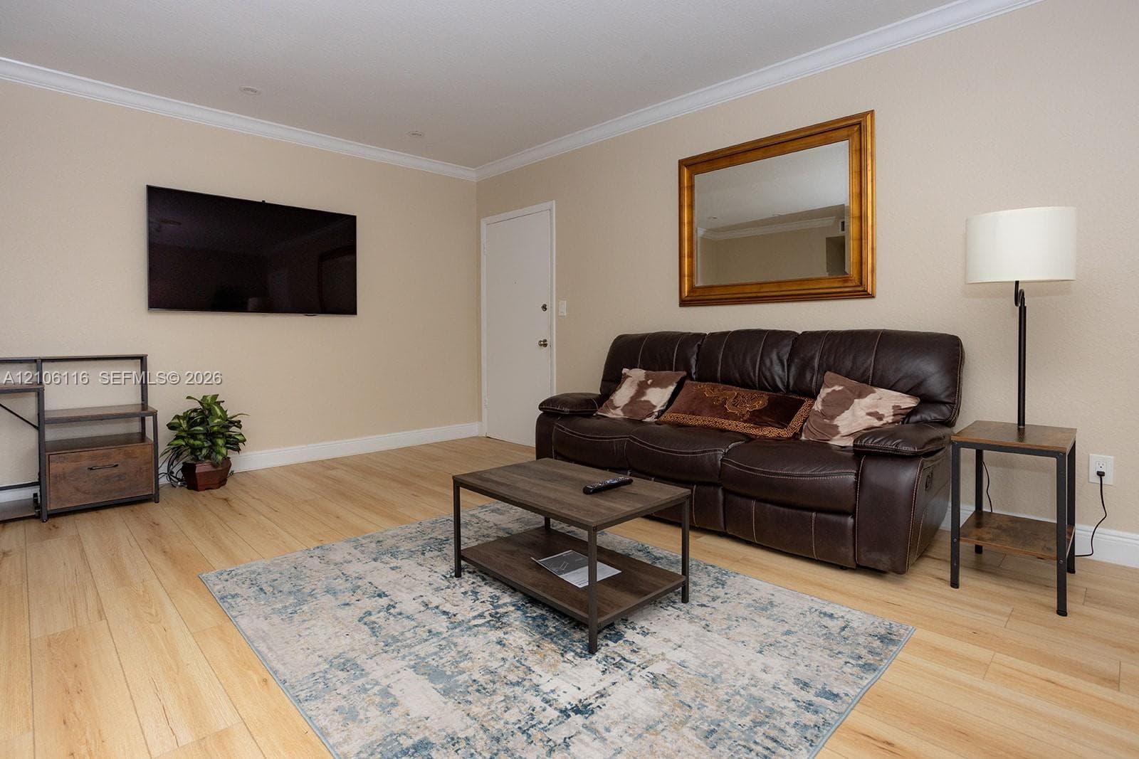 Neutral-toned walls featuring crown molding and light-toned wood-finish flooring