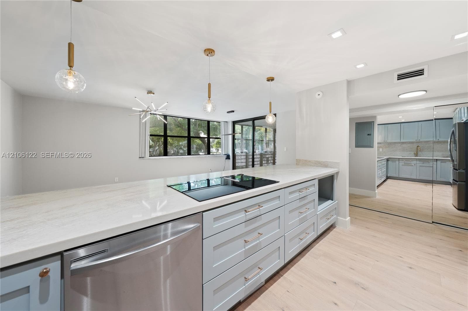 Kitchen featuring light-toned cabinetry, stone-finish countertops, an integrated cooktop, recessed lighting, and wood-finish flooring