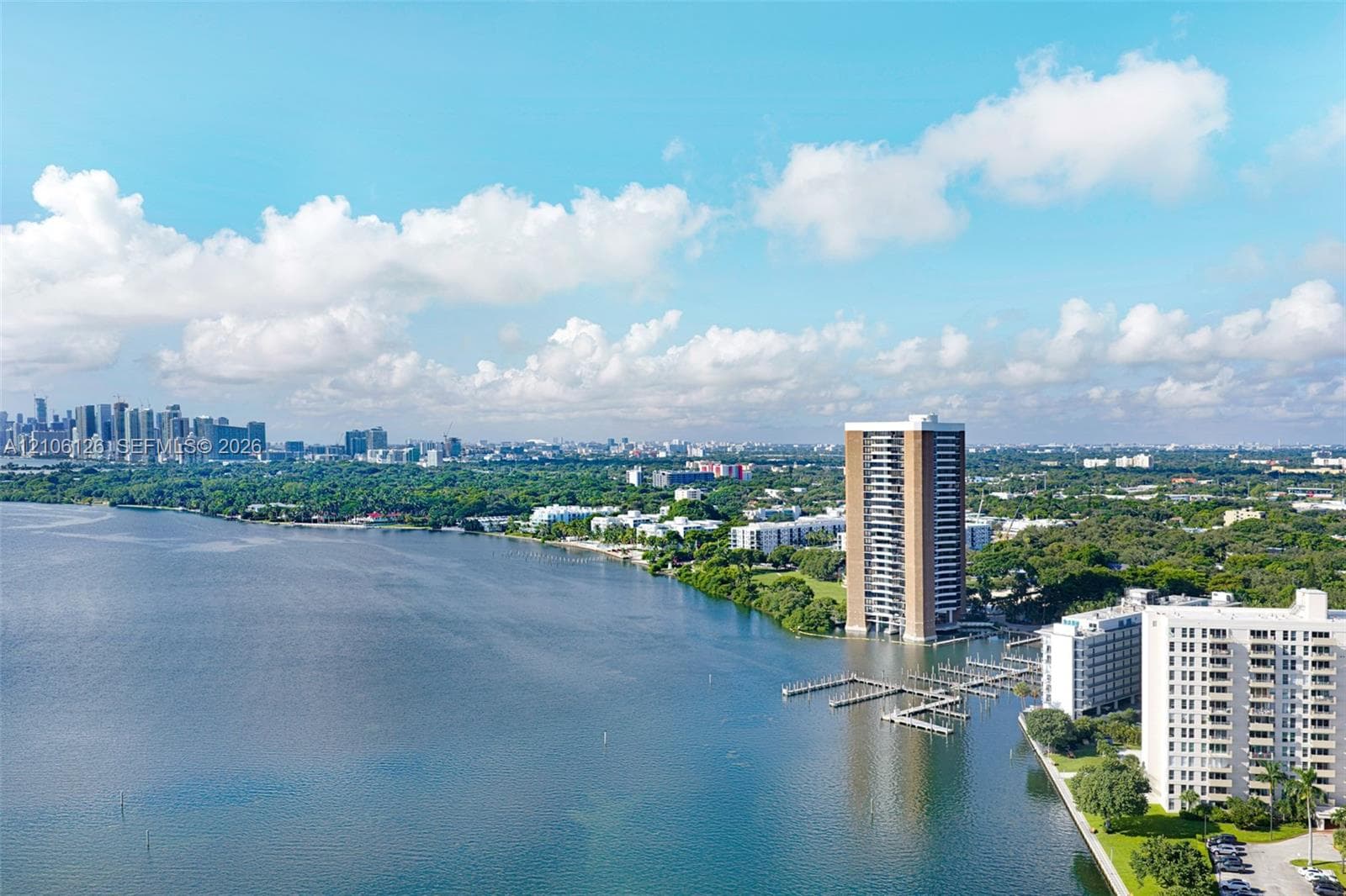 Aerial perspective featuring waterfront high-rise buildings, private boat slips, and extensive coastal vegetation