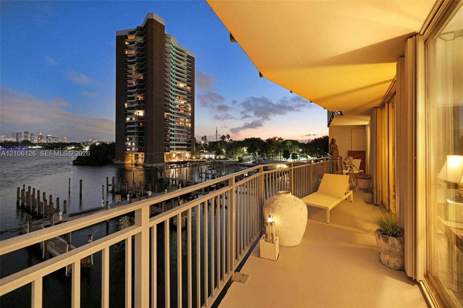 Spacious balcony with metal railings, retractable awning, and direct water frontage