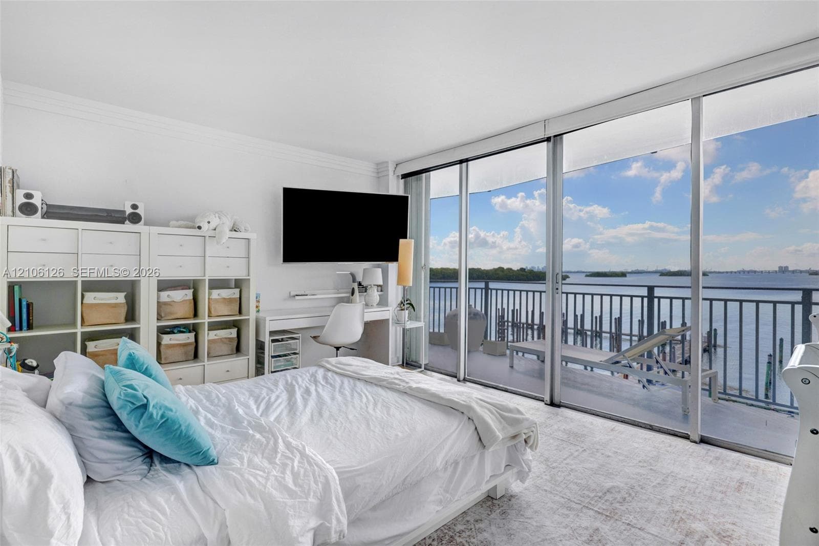 Private balcony featuring metal railings and concrete flooring, overlooking the water