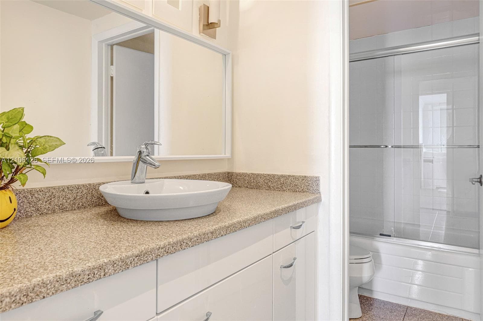 Textured feature wall, wood-finish flooring, and built-in headboard cabinetry
