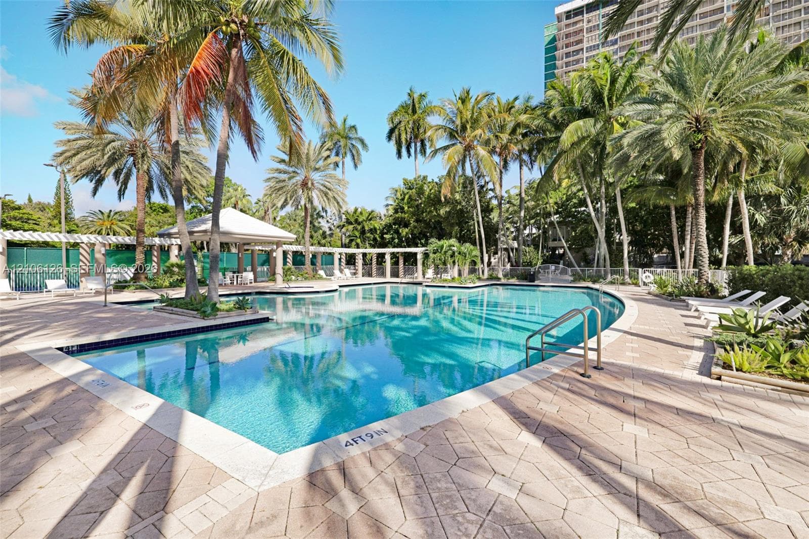 Waterfront property featuring a private wooden dock, mature palm foliage, and coastal scenery