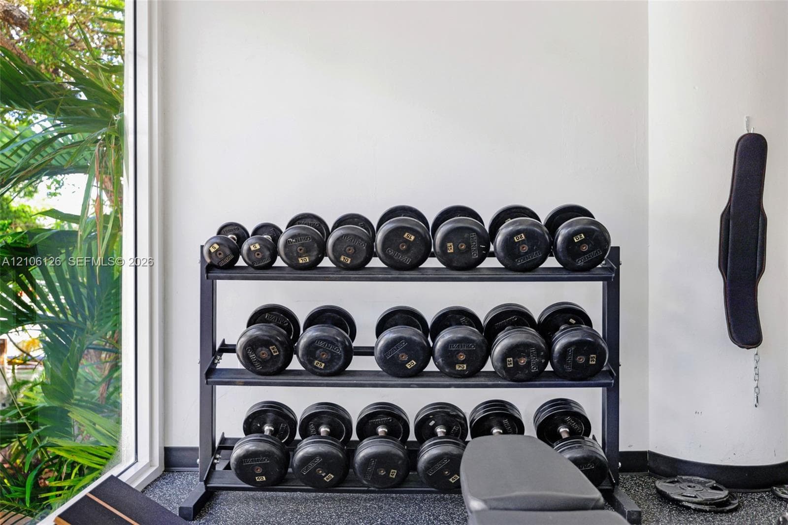 Fitness room featuring full-height floor-to-ceiling windows, recessed lighting, and durable rubber flooring