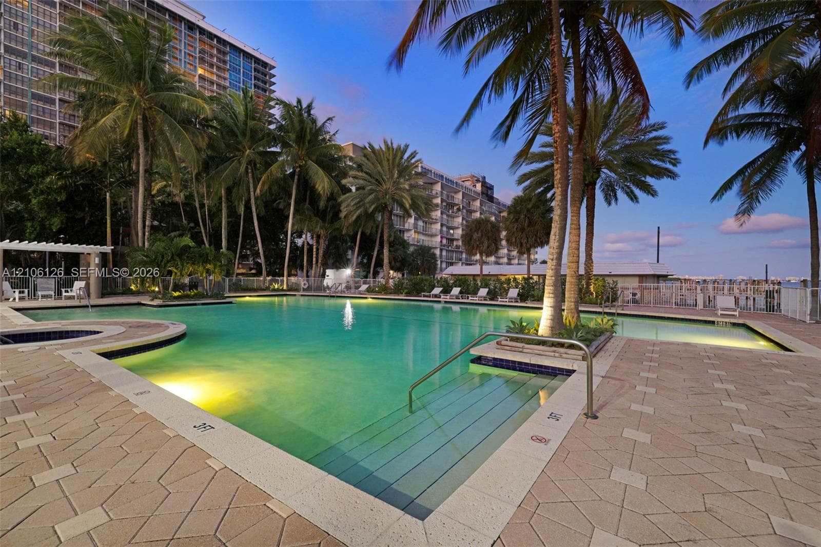 Waterfront property featuring multiple wooden boat docks and deep-water access with a distant city skyline backdrop