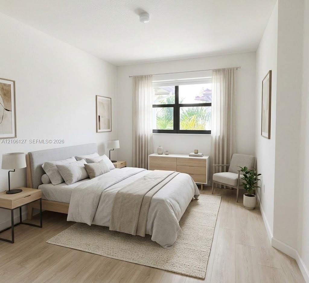 Bedroom featuring wood-finish flooring and a window with a dark-frame surround