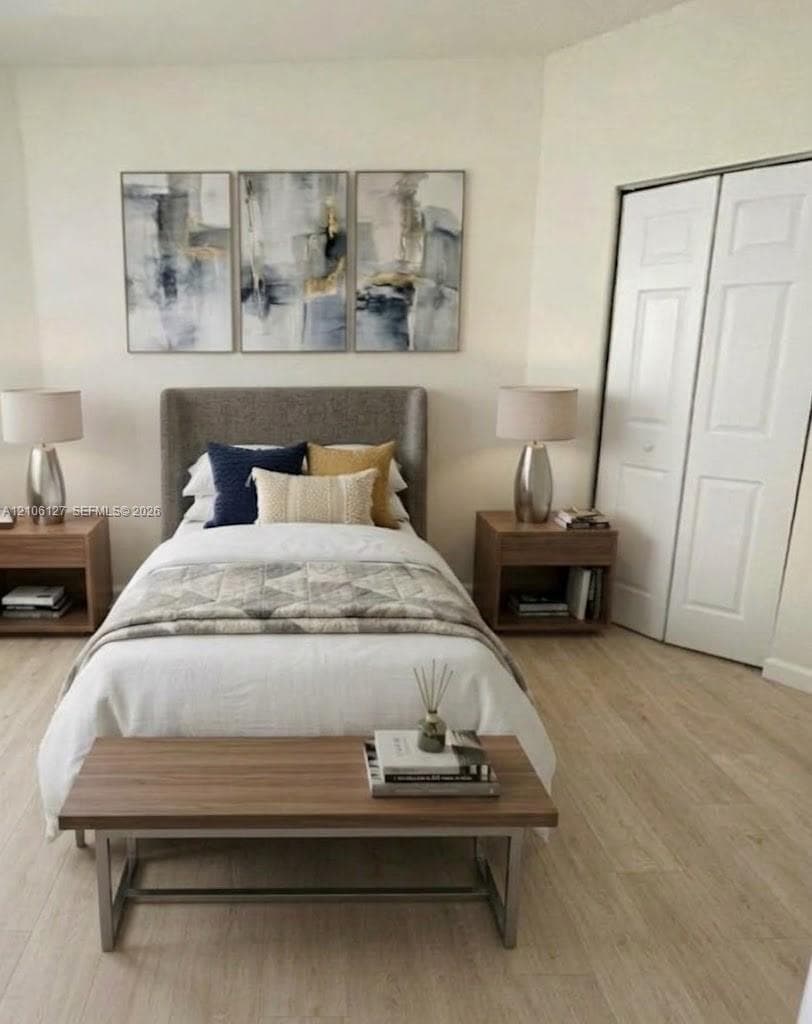 Neutral interior space featuring wood-finish flooring and a white-paneled closet door