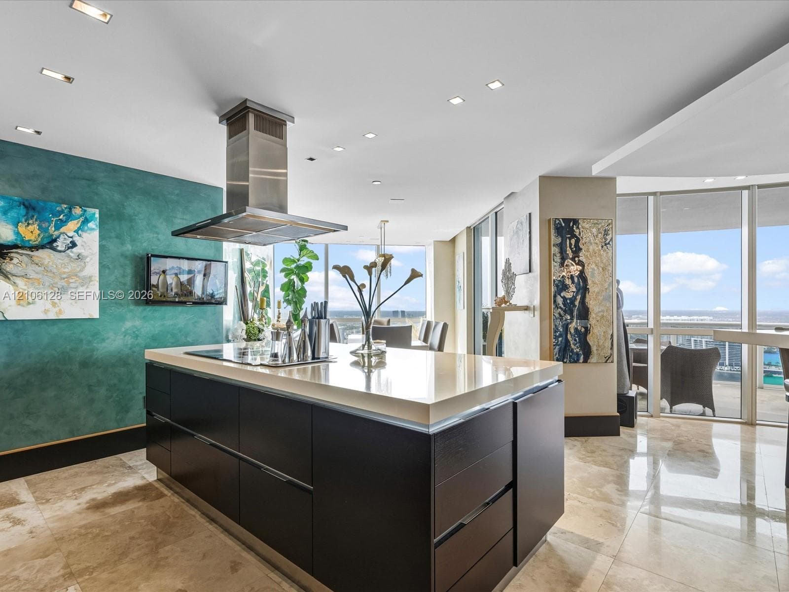 Kitchen featuring a center island with a stone countertop, dark cabinetry, a stainless steel chimney-style range hood, recessed ceiling lighting, and floor-to-ceiling windows