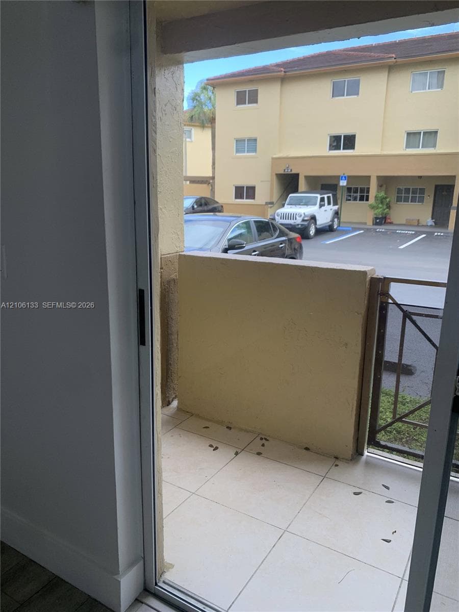 Private balcony featuring tile flooring and a solid stucco wall partition