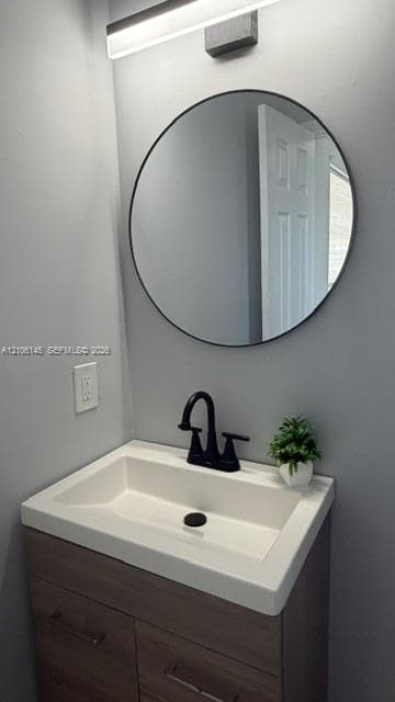 Wall-mounted vanity with a rectangular sink, matte black widespread faucet, circular mirror with a thin frame, and linear LED vanity light
