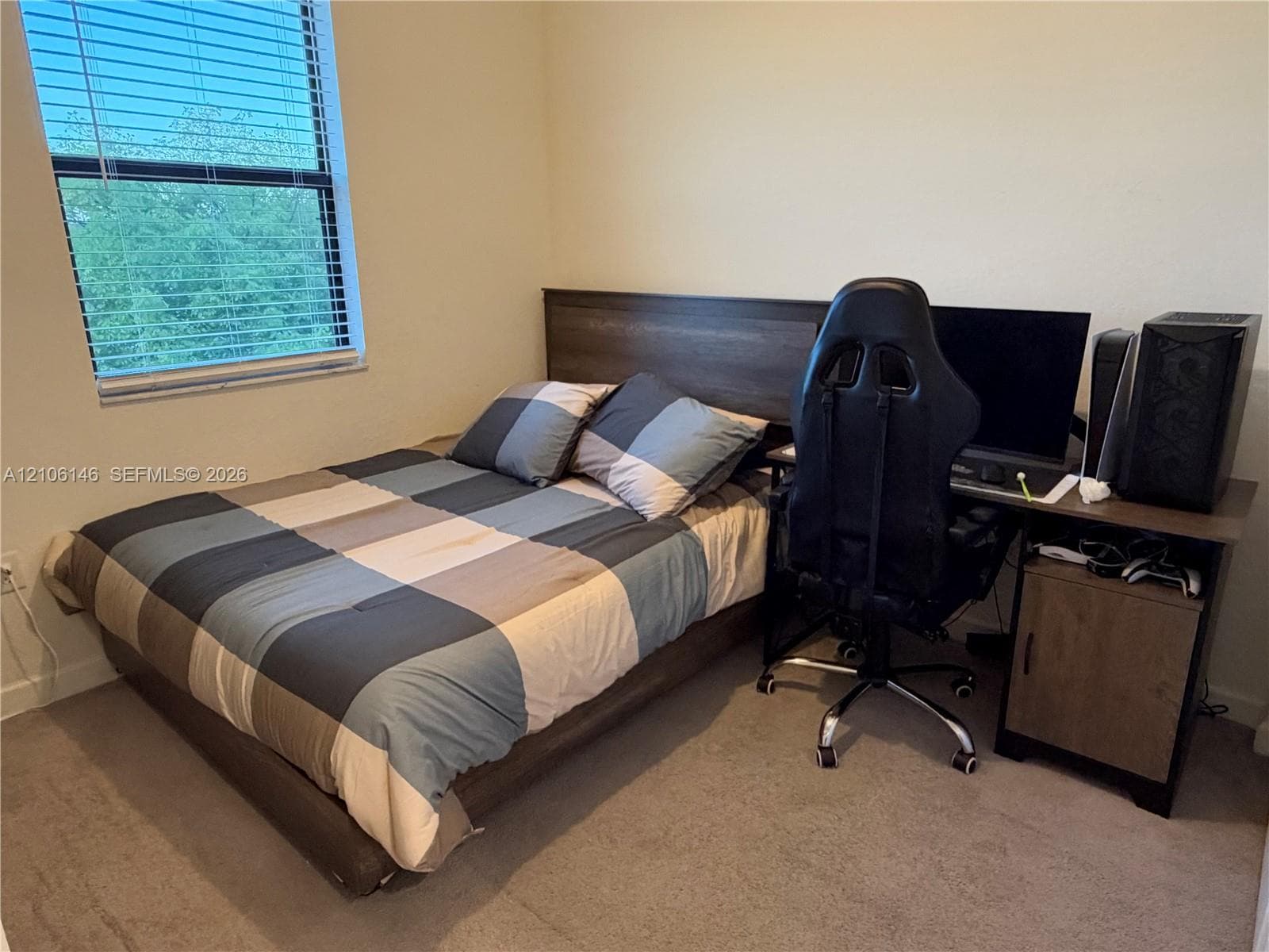 Bedroom featuring neutral wall paint, carpeting, and a large window with horizontal blinds