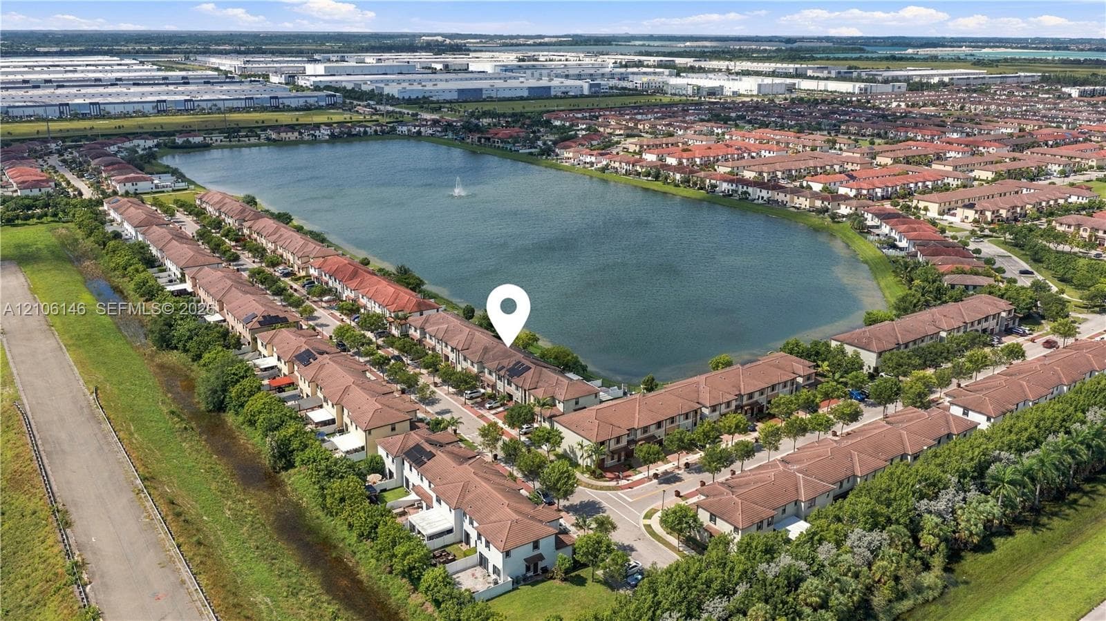 Aerial perspective featuring a two-story property with a tile roof, positioned along a shoreline