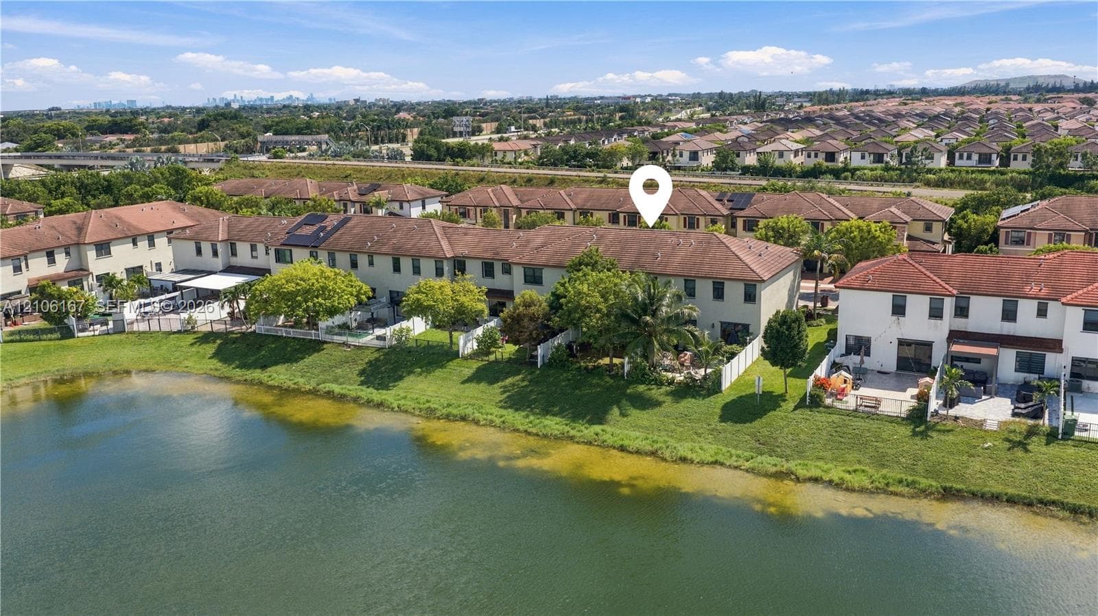 Two-story exterior featuring a tile roof and water-front placement with direct pond access