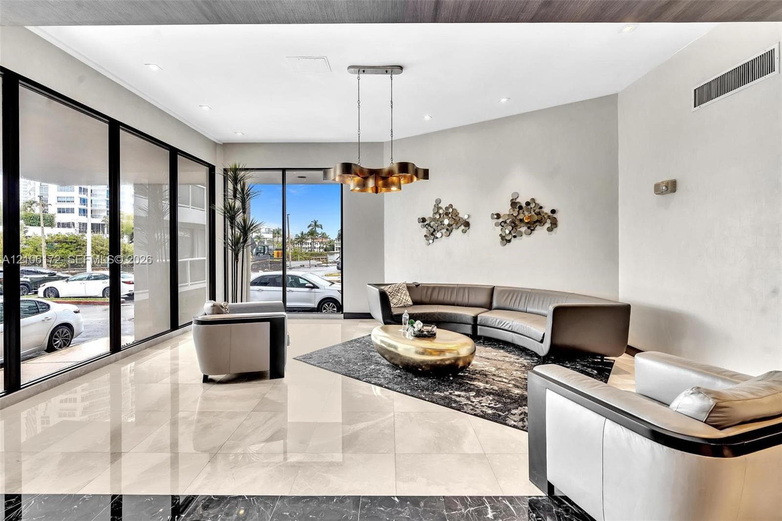 Floor-to-ceiling windows, polished stone flooring, recessed ceiling lighting, and a multi-tiered metal chandelier
