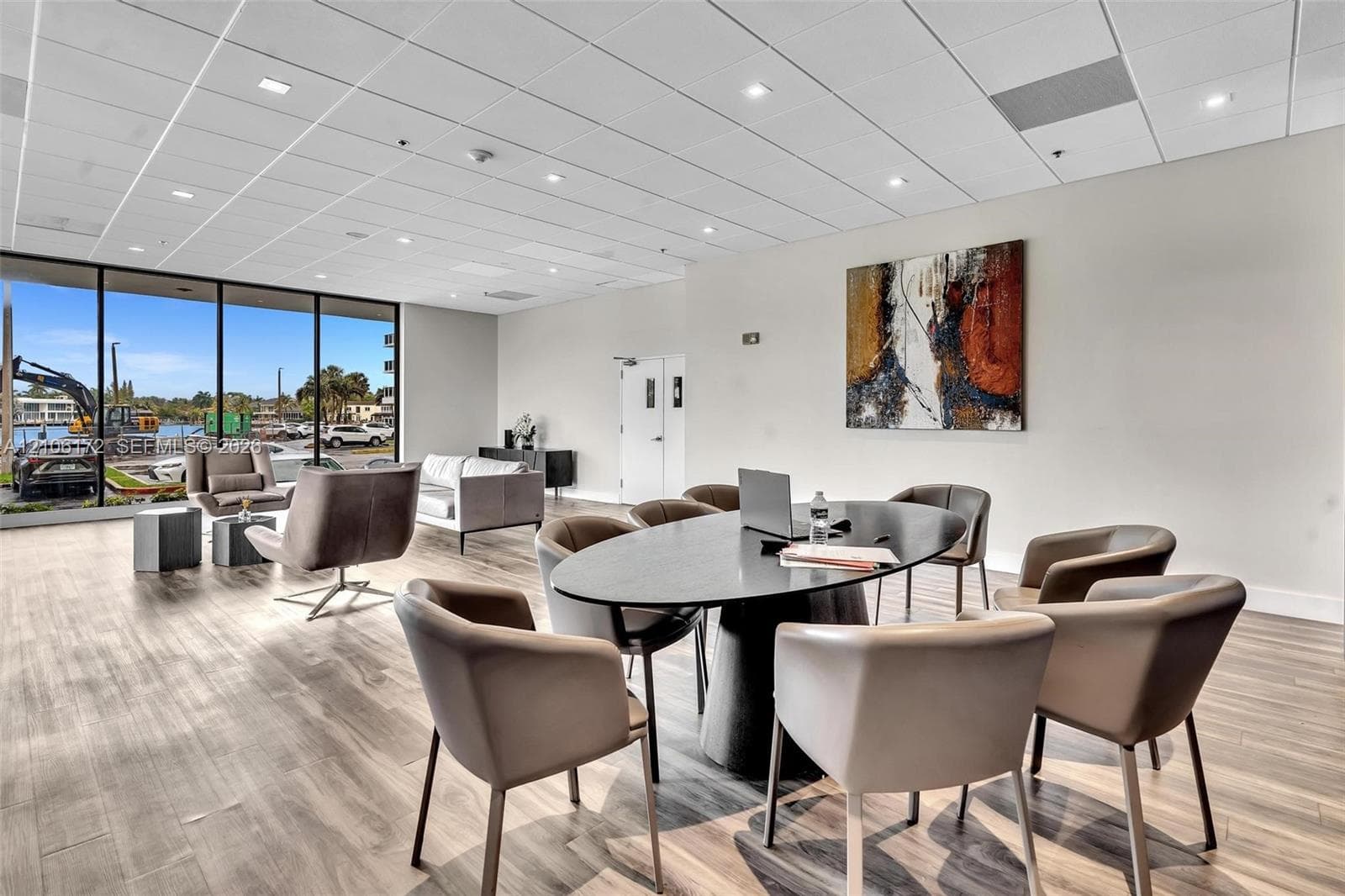 Open floor plan featuring wood-finish flooring, recessed lighting, drop ceiling grid, and floor-to-ceiling windows