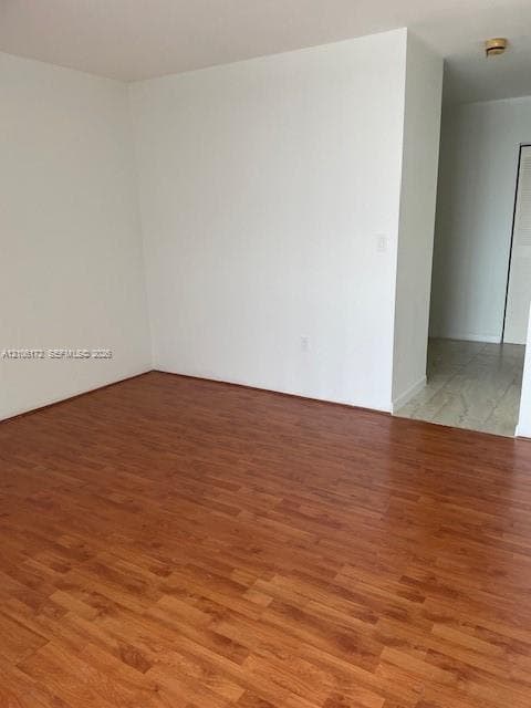 Neutral interior space featuring wood-finish flooring and ceramic tile flooring