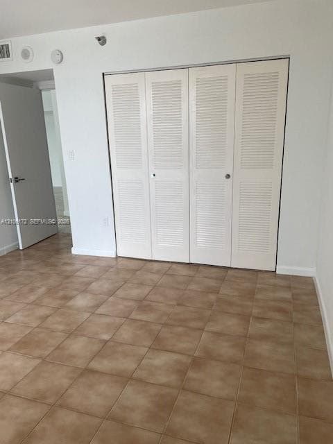 Ceramic tile flooring throughout and white bi-fold louvered closet doors