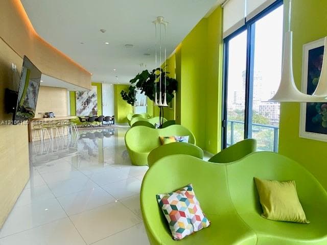 Polished tile flooring, floor-to-ceiling windows, built-in recessed lighting, and curved wood-paneled wall feature