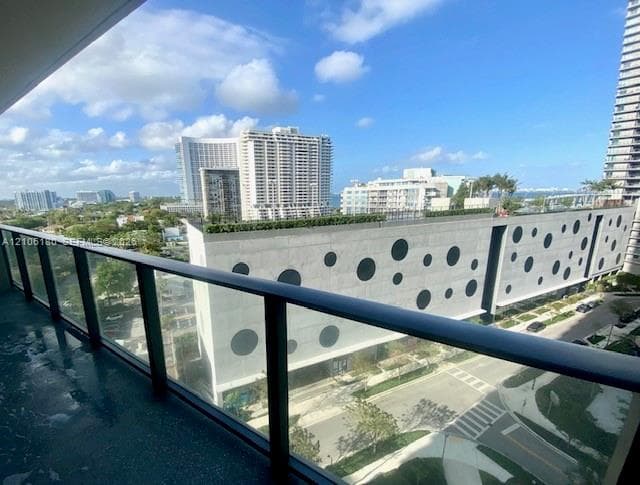 Private balcony featuring a glass panel railing and concrete flooring