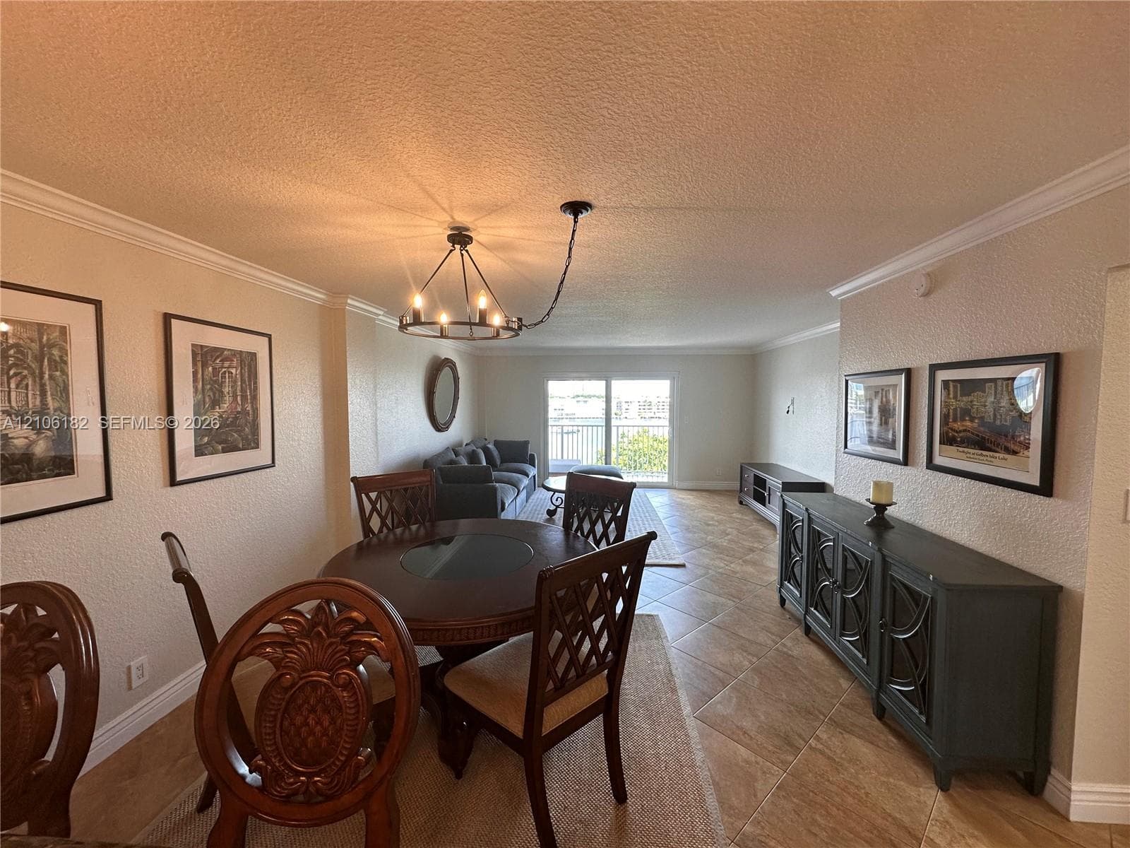 Open interior featuring diagonal tile flooring, crown molding, and a custom chandelier