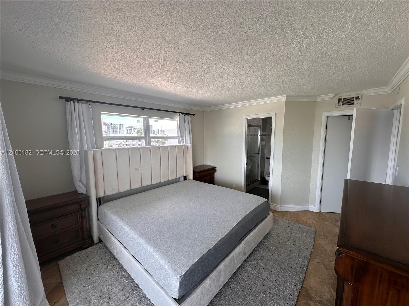 Neutral-toned room featuring stone-finish flooring and crown molding
