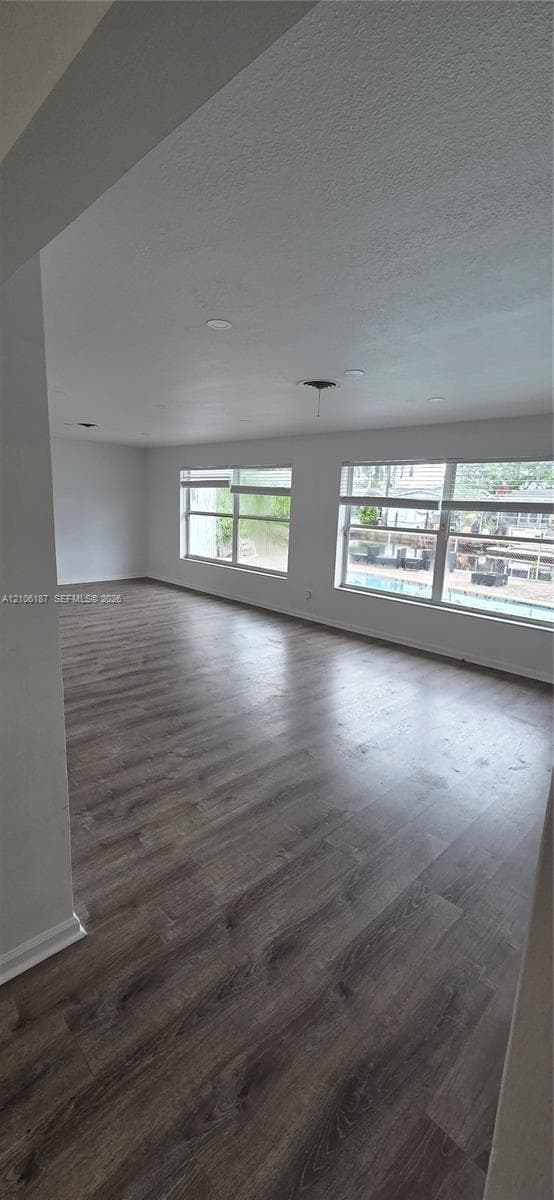 Open-concept area featuring wood-finish flooring, recessed lighting, and multiple large windows