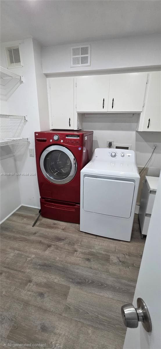 Laundry area featuring wood-finish flooring, white wall-mounted cabinetry, and integrated wire shelving