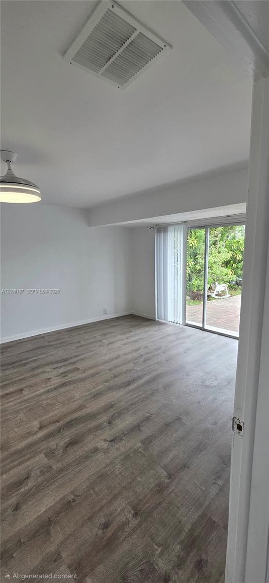 Interior space featuring wood-finish flooring, sliding glass door, and integrated ceiling light fixture
