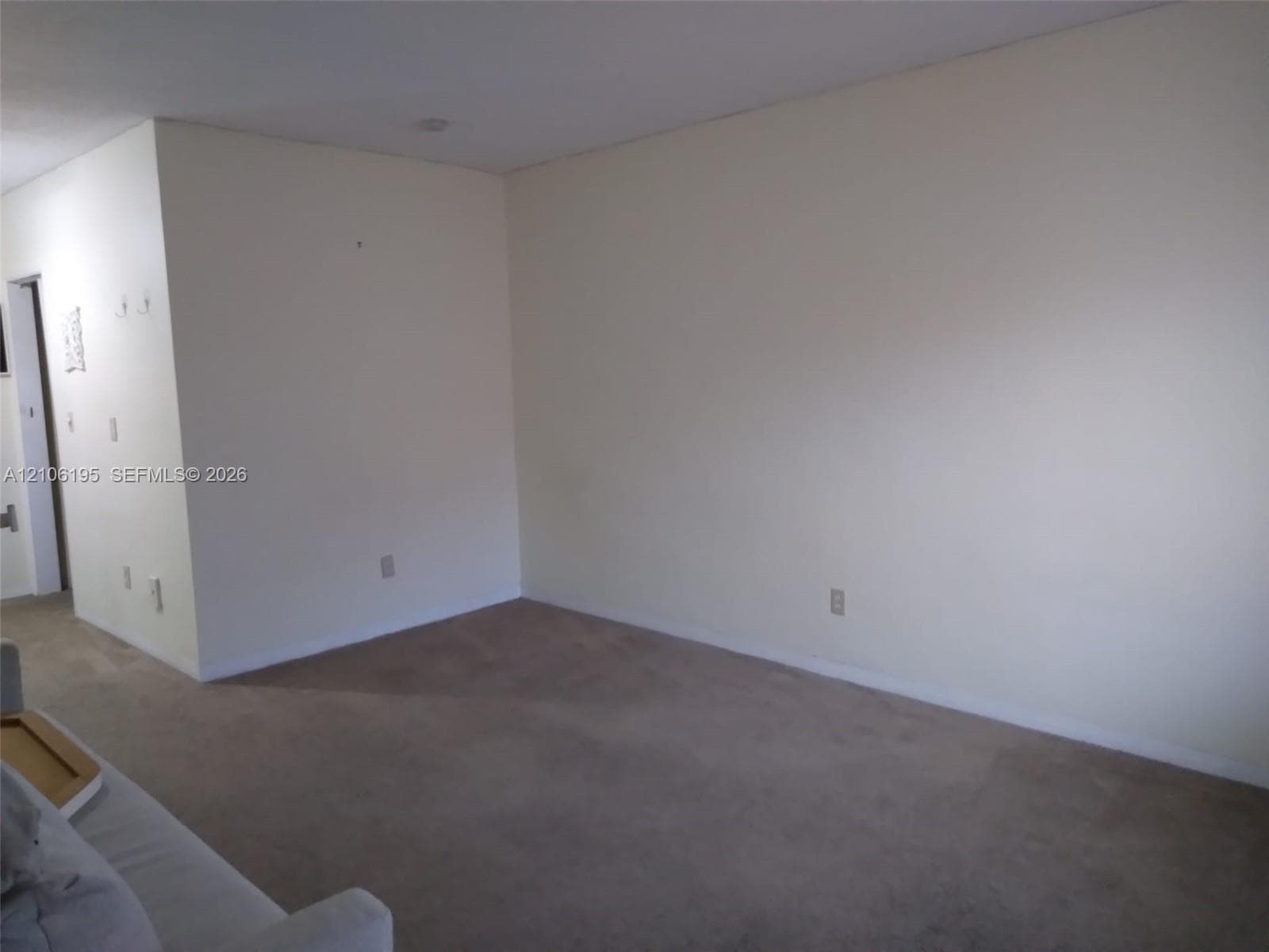 Neutral wall finish with carpeting and flush-mount ceiling lighting