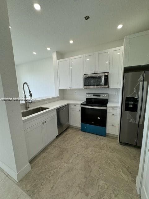 Kitchen featuring white shaker-style cabinetry, stainless steel appliances, solid surface countertops, a deep undermount sink with a gooseneck faucet, and large-format tile flooring