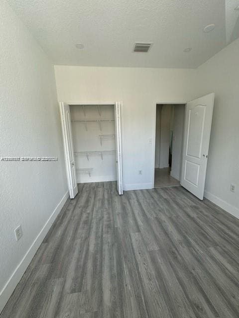 Room featuring wood-finish flooring, recessed lighting, and a closet with built-in wire shelving