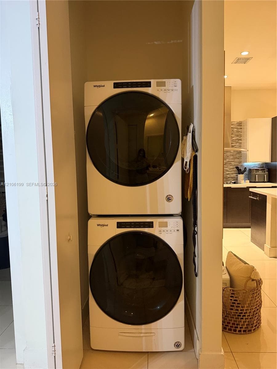 Stacked, front-loading washer and dryer unit housed within a dedicated closet