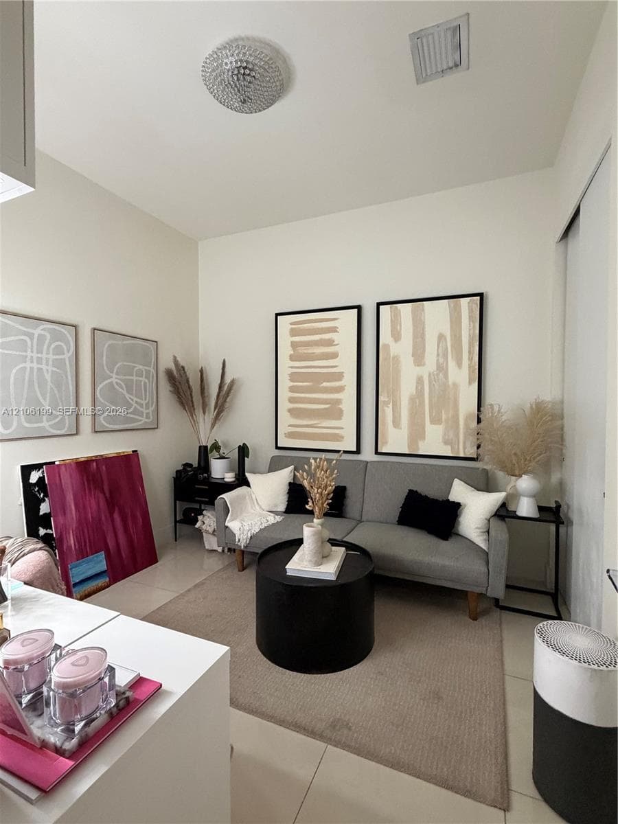 Neutral tile flooring, crisp white walls, and a decorative circular flush-mount ceiling light fixture