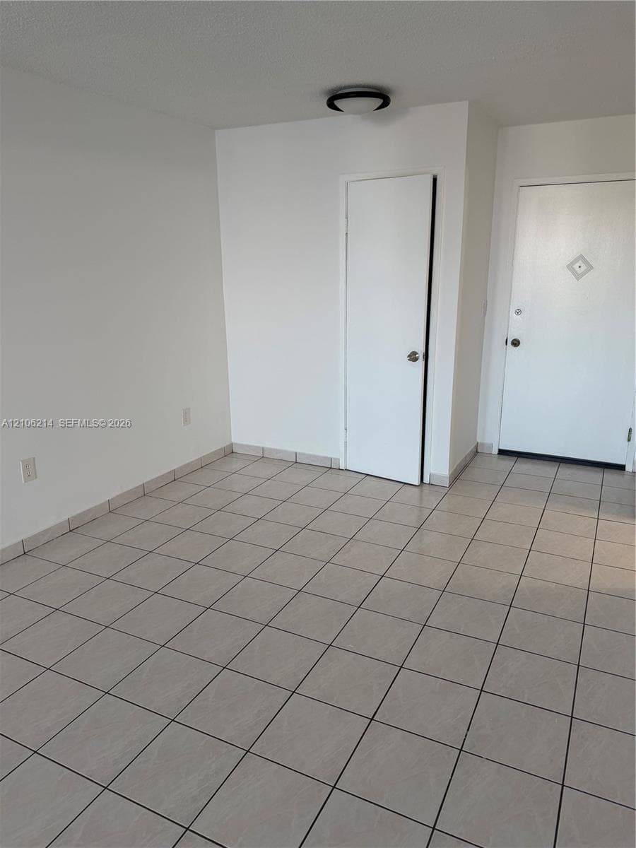 Neutral-toned ceramic tile flooring, solid-core interior doors, and low-profile flush-mount ceiling lighting