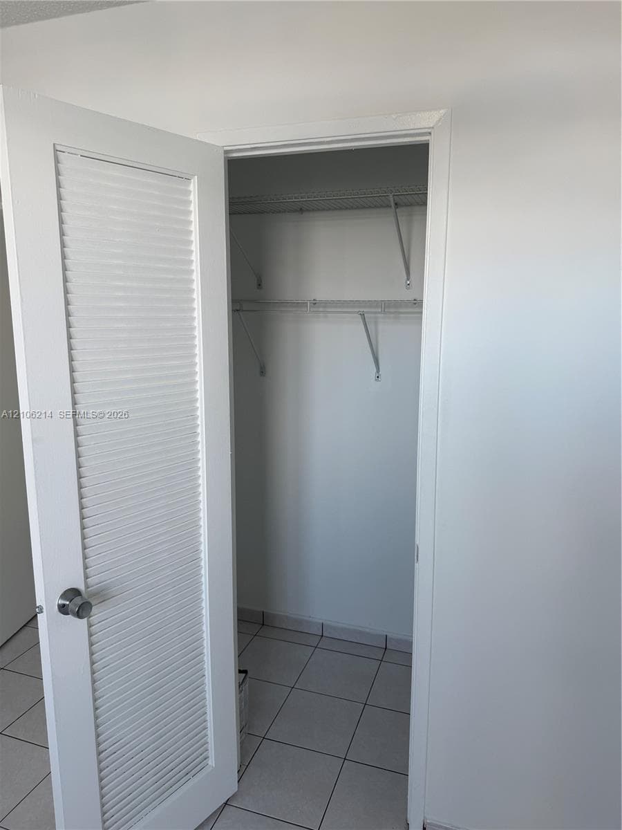 Closet featuring louvered door, white wall finish, and wire shelving