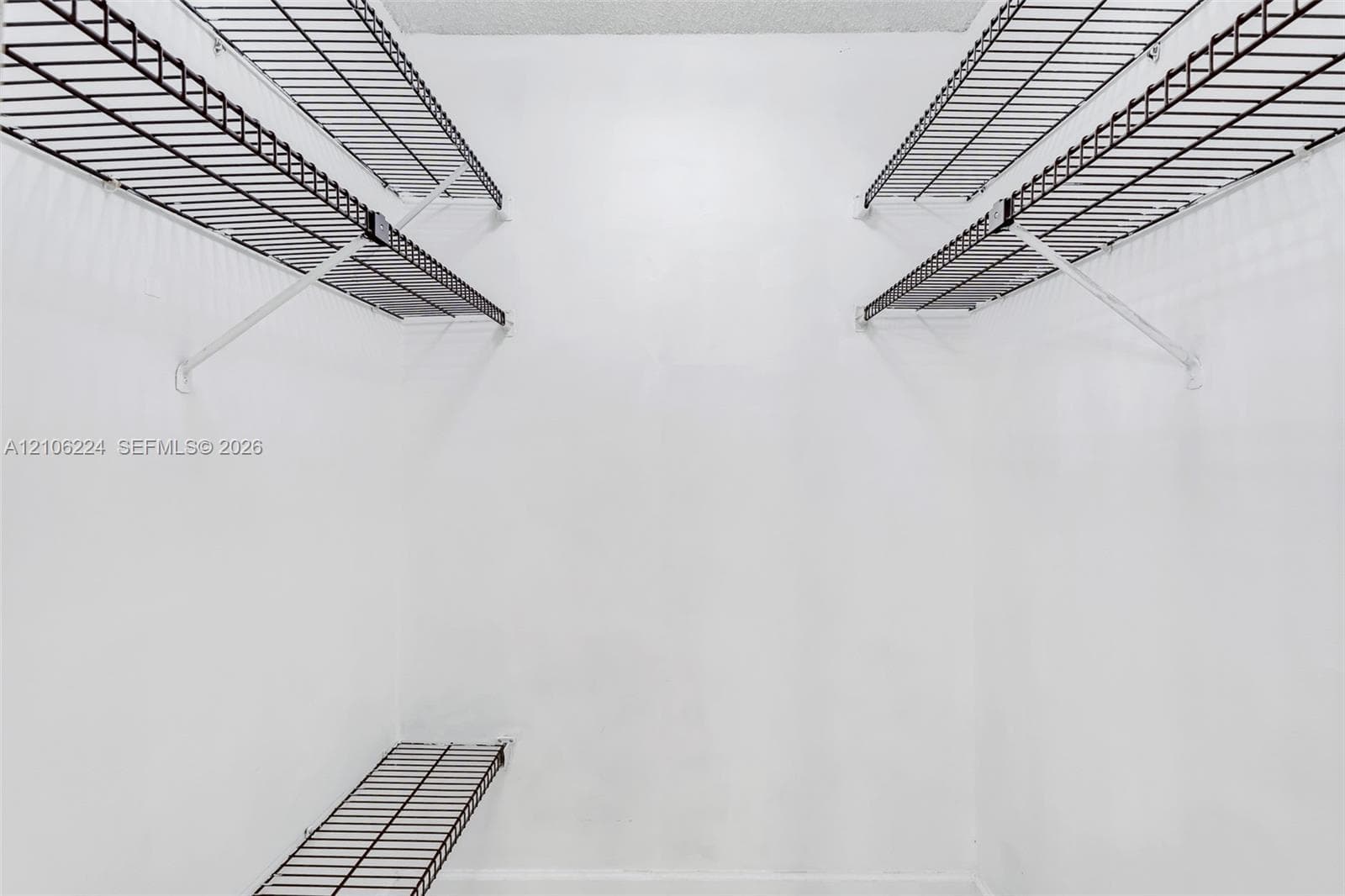 Storage area featuring multi-level wire shelving units and white walls