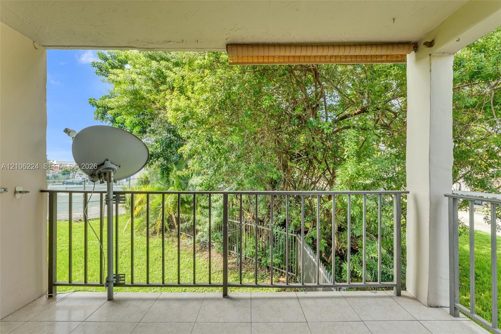 Covered balcony featuring tile flooring and metal railings