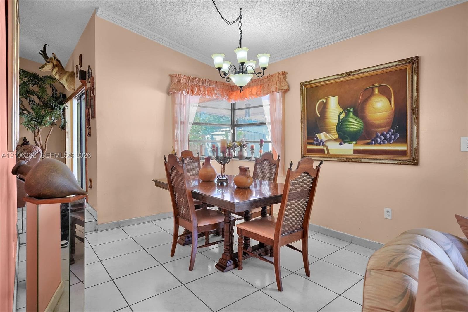 Dining area featuring large-format ceramic tile flooring, crown molding, a corner window configuration, and a multi-arm chandelier