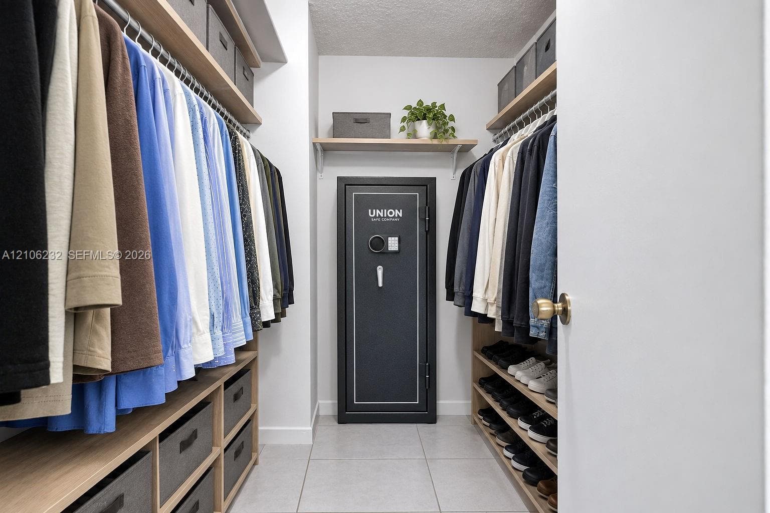 Walk-in closet featuring multi-level wooden hanging rods, integrated wooden shelving, built-in lower drawers, and tile flooring