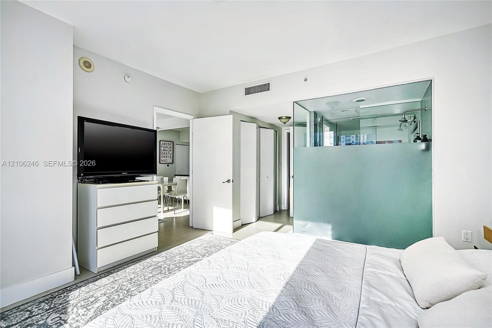 Glass-enclosed shower with frosted privacy panel, ceiling-mounted sprinkler head, and smooth-finish walls
