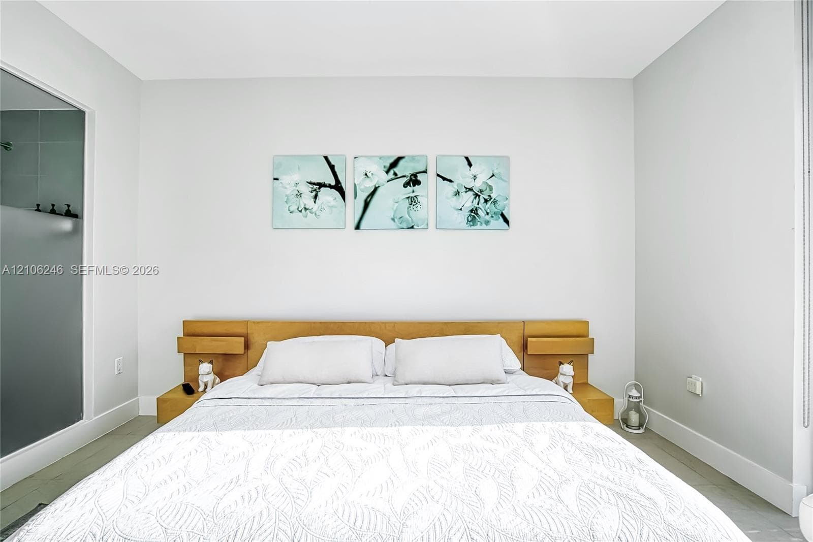 Built-in wood-finish headboard featuring integrated side shelving and neutral wall finishes