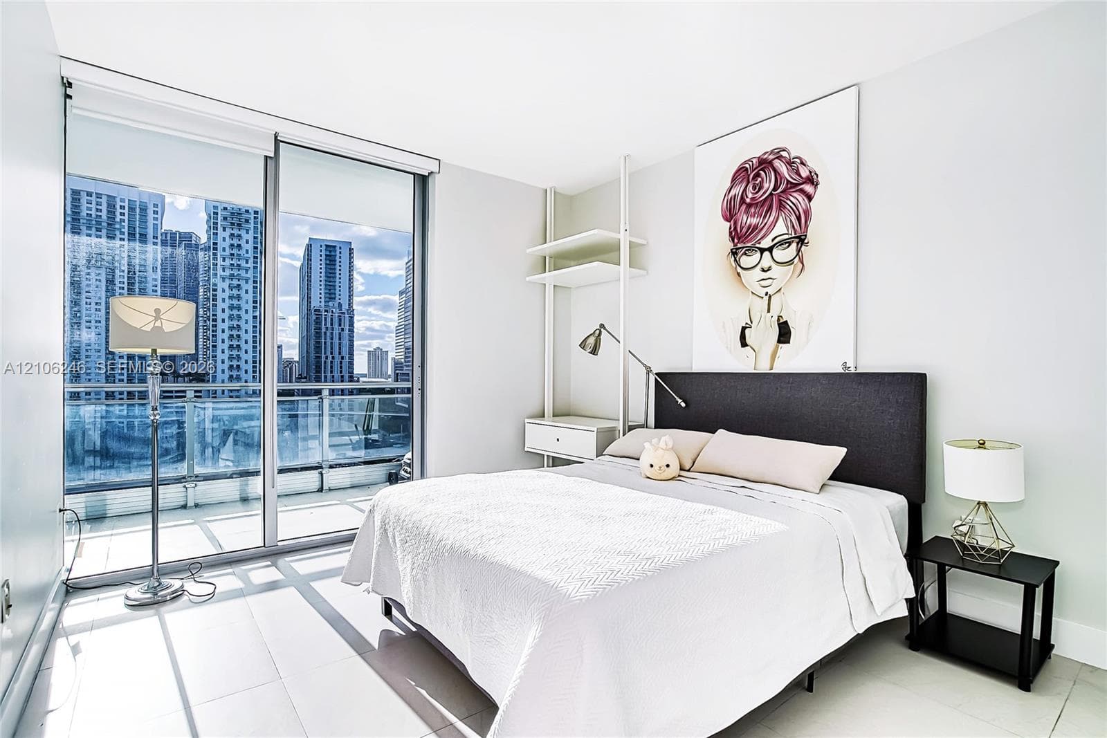 Floor-to-ceiling glass sliding doors, private balcony with glass railing, large-format tile flooring, and custom built-in shelving unit